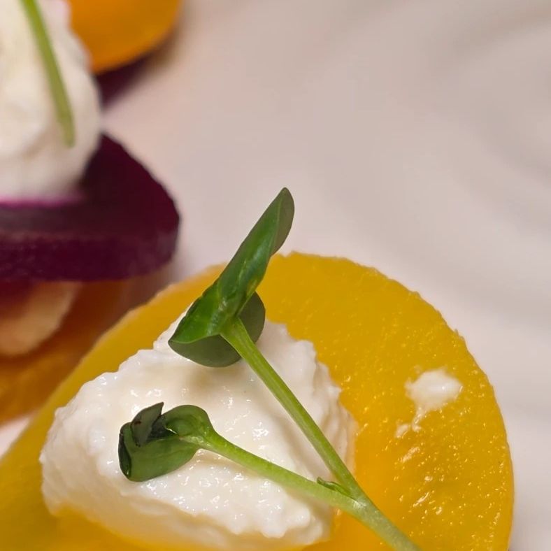 A beetroot and citrus plate with a quenelle of soft cheese
